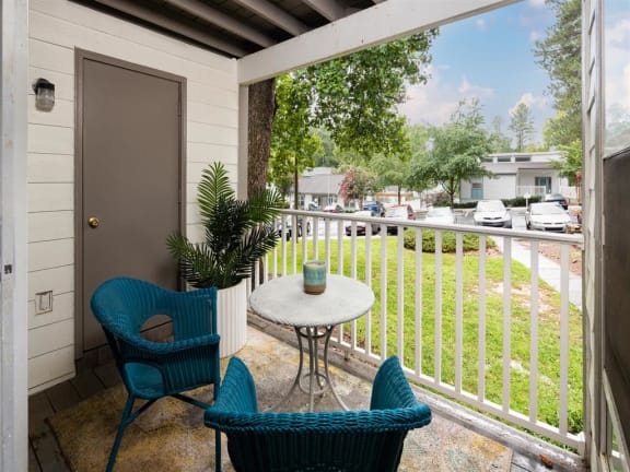 a patio with two chairs and a table on a balcony