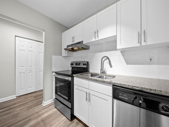 a kitchen with white cabinets and black appliances