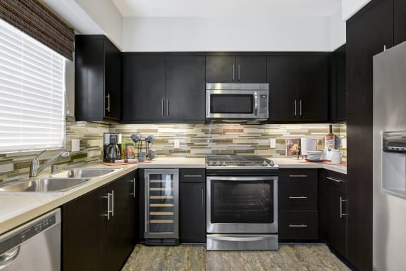 Soft Close Cabinets &amp; Drawers in kitchen with black cabinets at Avino in San Diego, CA 92130