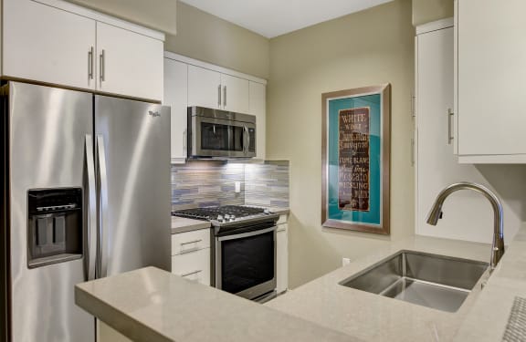 Kitchen with stainless steel appliances and a sink at Avino in San Diego,92130