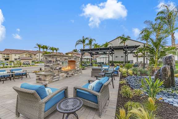 A patio with blue cushions and a fireplace.