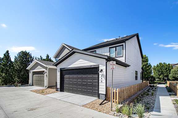 A modern house with a garage and a no parking sign in front.