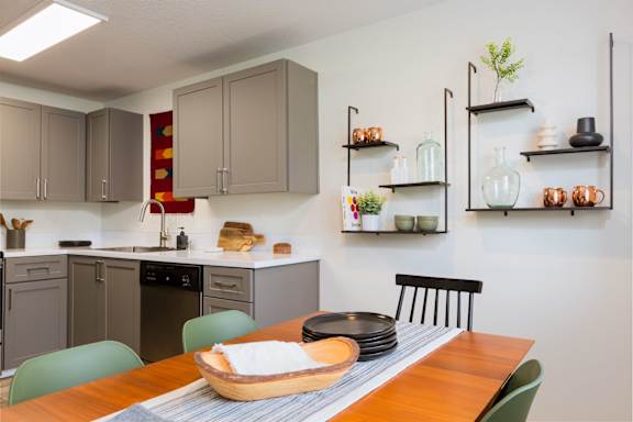 A kitchen with a table set for two.