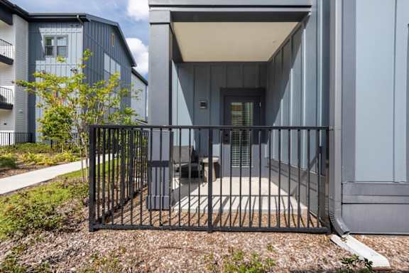 A modern house with a black gate in front.
