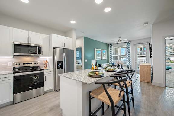 A kitchen with a table and chairs in front of a window.