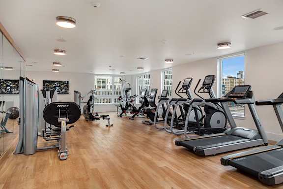 A gym with treadmills, elliptical machines, and other exercise equipment.