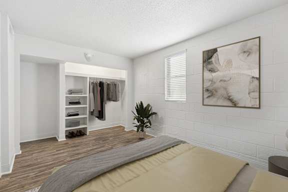 A bedroom with a bed, a wardrobe, and a painting on the wall.