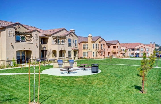 A sunny day at a residential area with houses and a green lawn at RiverEdge Terrace* Apartments, California, 92154