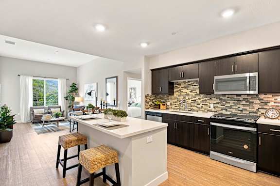 A modern kitchen with dark brown cabinets and a white island.