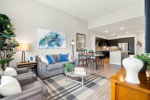 A living room with a grey couch and a blue pillow.