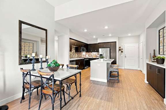 A kitchen with a dining table and chairs.