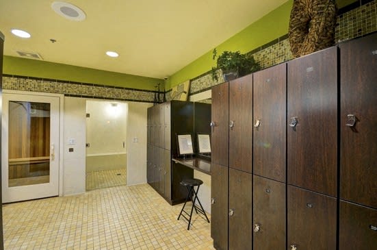 A room with a green wall and a row of wooden lockers.