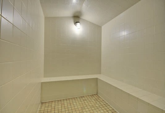 A white tiled shower with a shower head at RiverEdge Terrace* Apartments, California, 92154