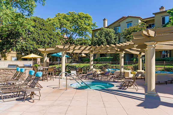 A pool area with sun loungers and a pergola.