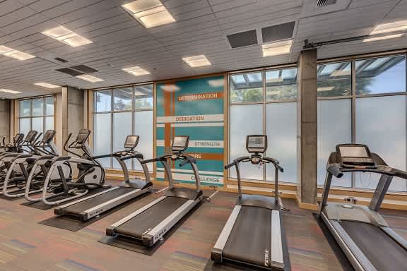 A gym with treadmills and a sign that says "Determination".