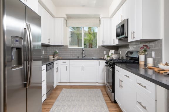 a kitchen with stainless steel appliances and white cabinets