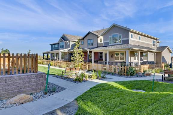 A house with a grey roof and a wooden fence.