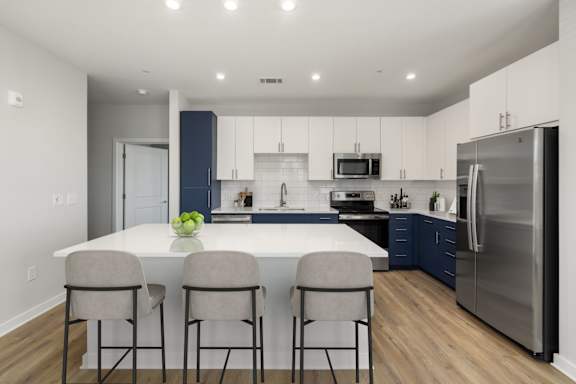 A modern kitchen with a large island and bar stools.