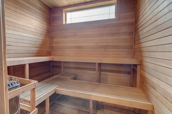 A wooden sauna with benches and a window.