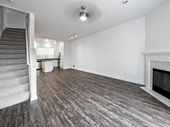 A spacious living room with a fireplace and a staircase.