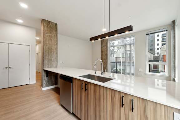 A modern kitchen with wooden cabinets and a large island. at Ion Town Center, Shoreline, WA