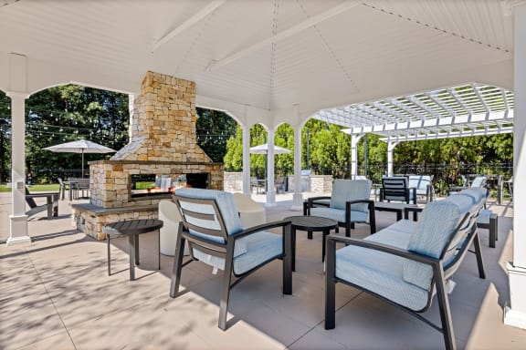 the outdoor patio has a fireplace and tables with chairs