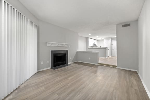 a living room with a fireplace and wood flooring