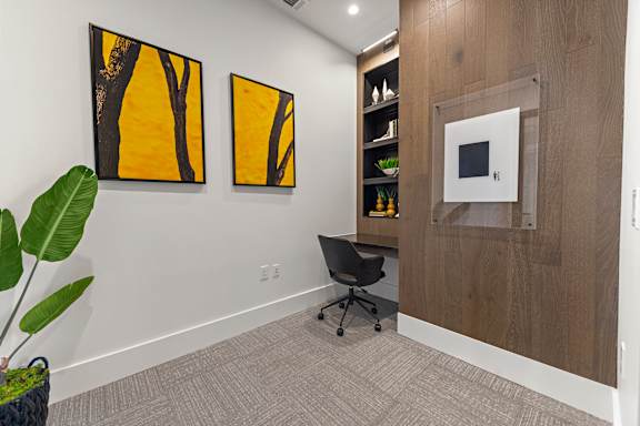 A room with a chair and a painting on the wall.