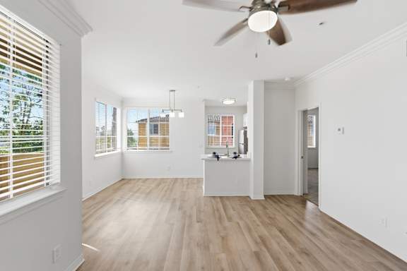 A room with a ceiling fan and wooden flooring.