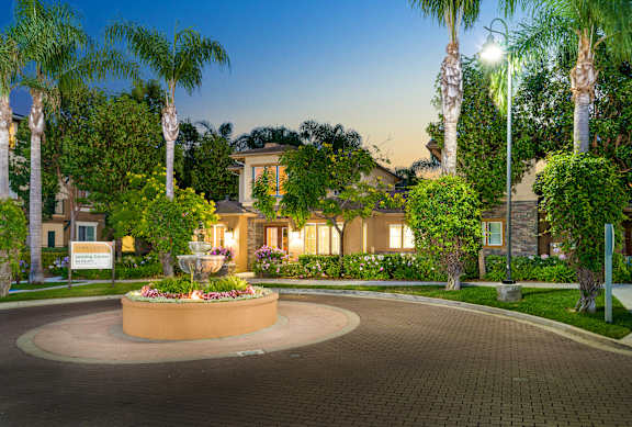A beautifully lit entrance to a home with a fountain in the middle.