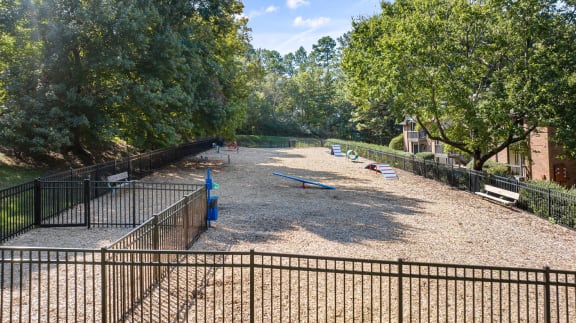 a playground in a park with benches and trees