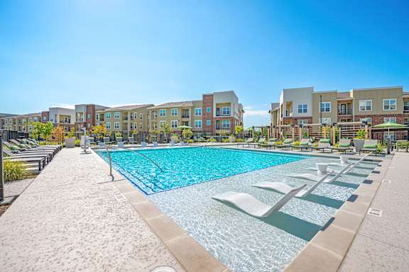 A swimming pool in front of apartment buildings.