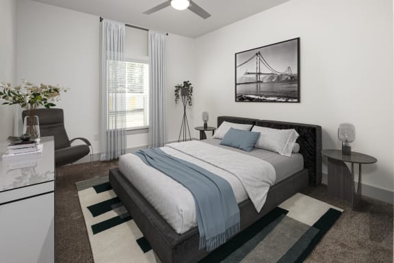 an open bedroom with a bed and a couch and a window