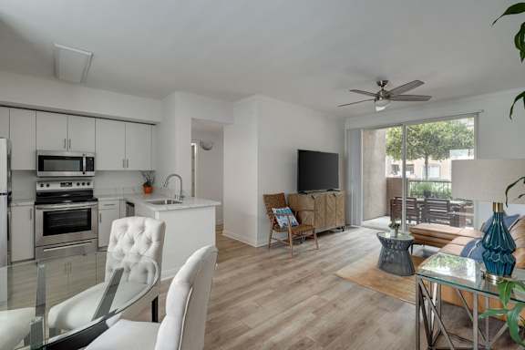 A modern kitchen with a dining area and a living room.