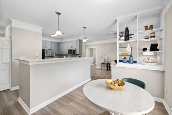 an open kitchen and dining room with a white counter top and a table