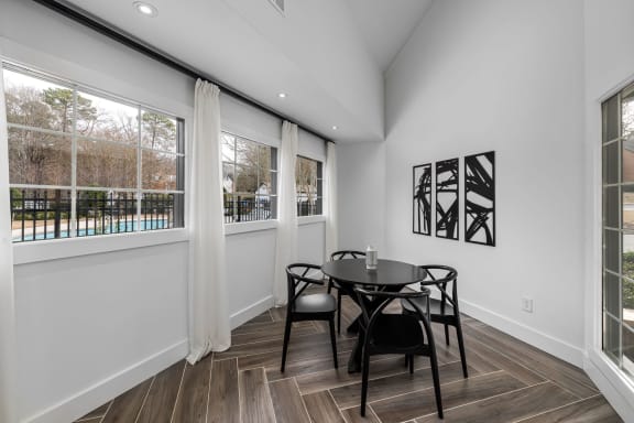 a dining room with a table and chairs and large windows