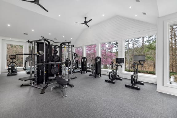 a gym with a lot of exercise equipment and windows