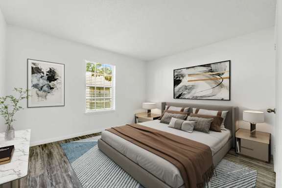 A bedroom with a large bed and a painting on the wall.