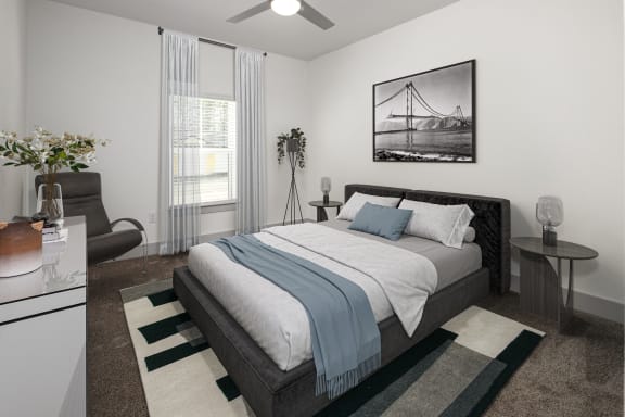 an open bedroom with a bed and a couch and a window