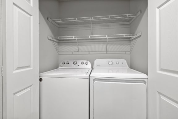 an empty laundry room with two washes and a dryer