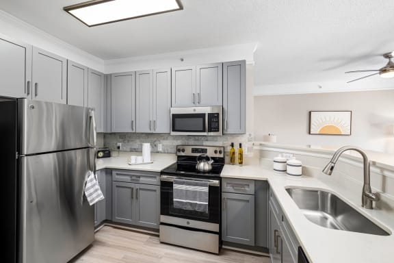a kitchen with stainless steel appliances and gray cabinets