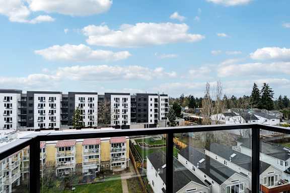A view from a balcony overlooking apartment buildings and a parking lot. at Ion Town Center, Shoreline