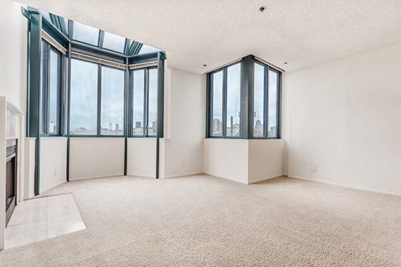 an empty living room with a view of a city