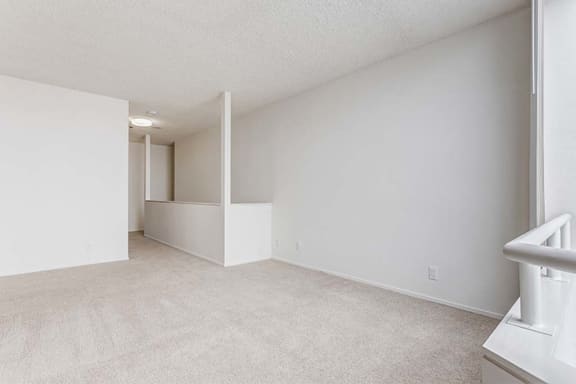 an empty room with white walls and carpet