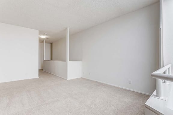 an empty bedroom with white walls and carpet