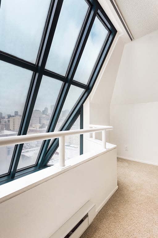 a room with a large window and a white railing