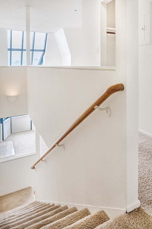 a white staircase with a wooden hand rail