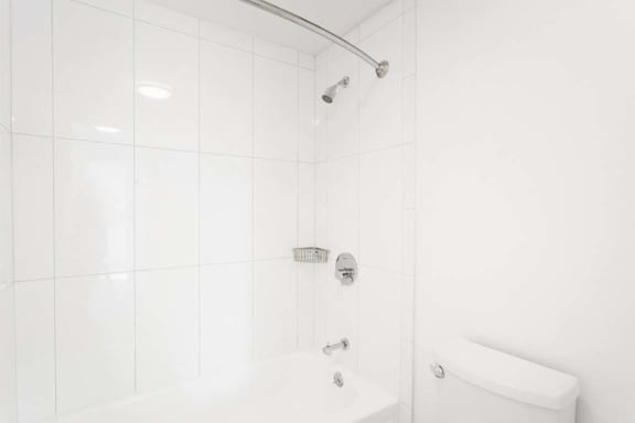 a white bathroom with a shower and a toilet