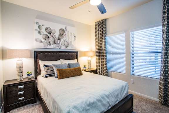 A bedroom with a large bed and a painting on the wall.