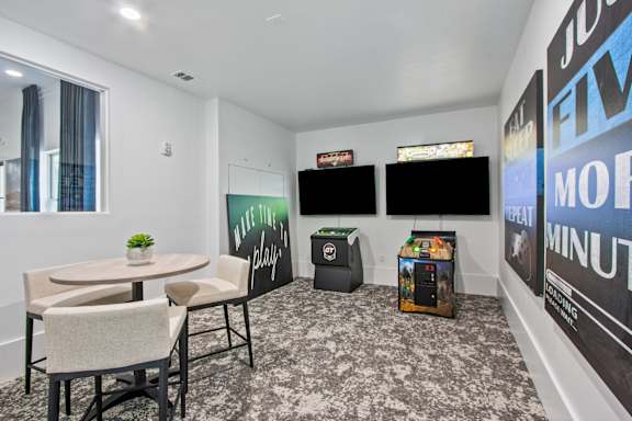 A room with a table, chairs, and a TV.